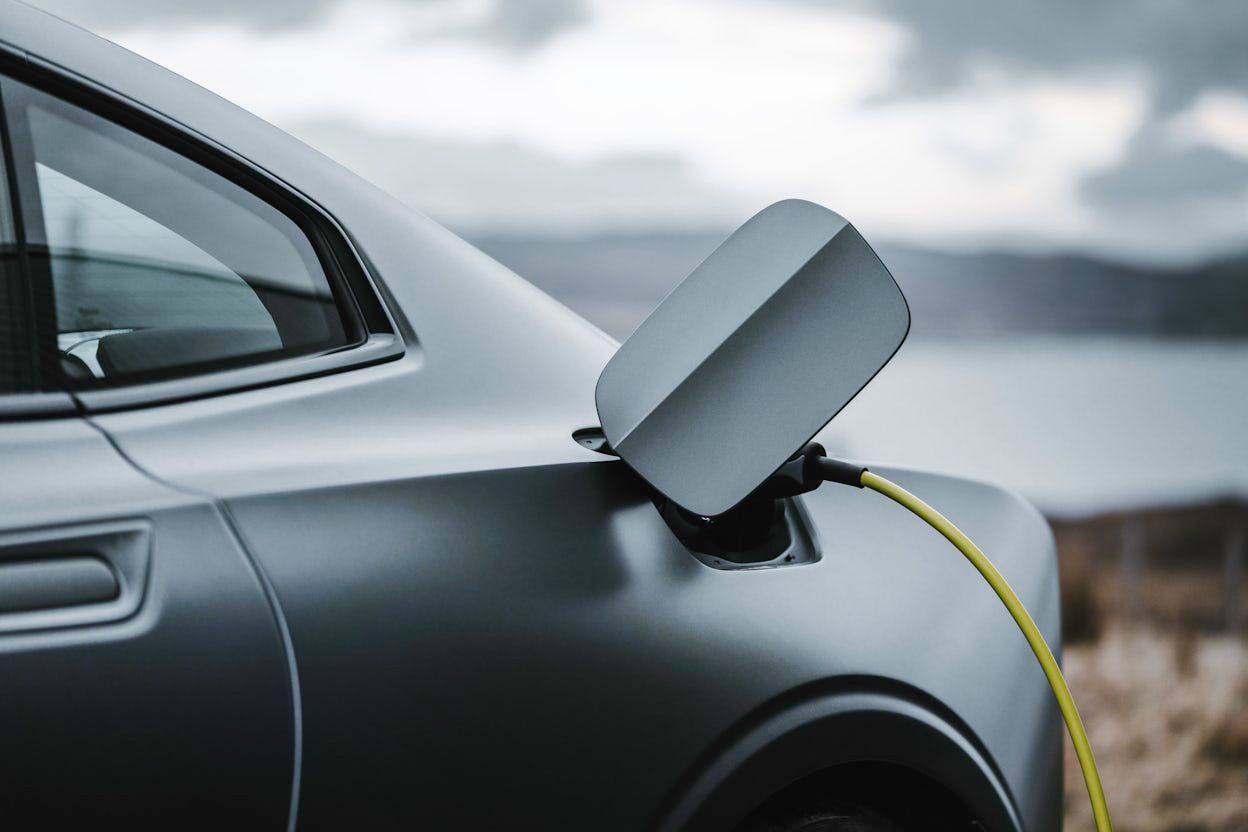Close-up of a grey Polestar 1 with the charging cable connected.