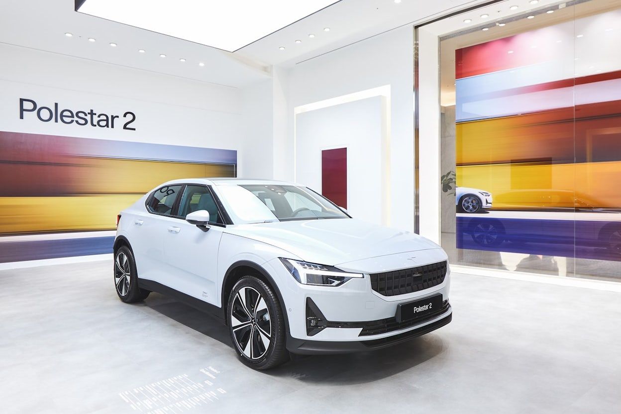 White Polestar 2 in a space with colourful blurry background and window