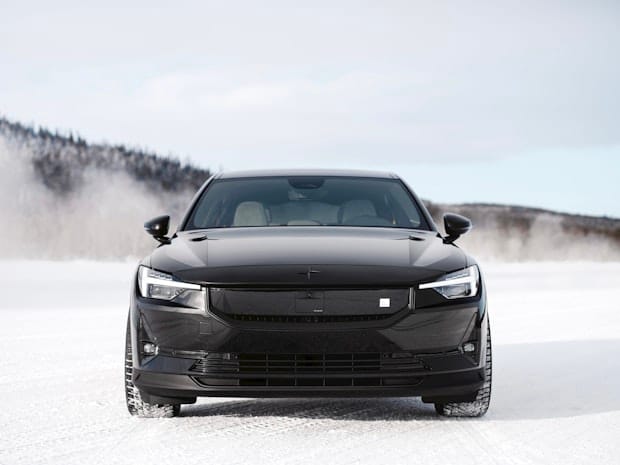 Front view of a pristine black Polestar 2 parked in a snowy landscape.