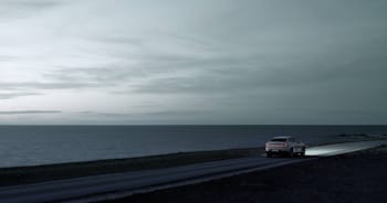 Polestar 2  rear view driving next to the sea