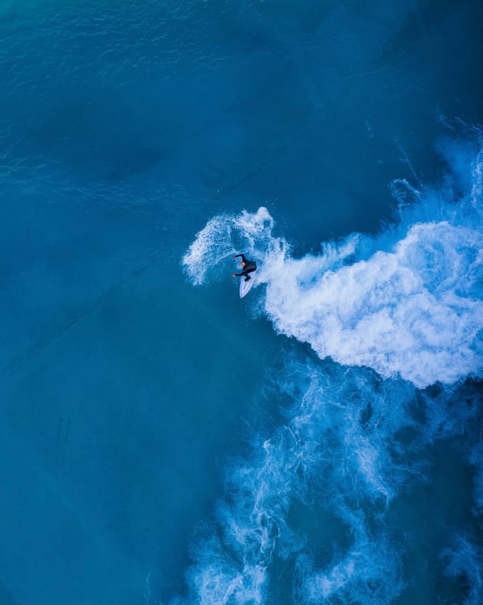 Aerial view of surfer riding wave