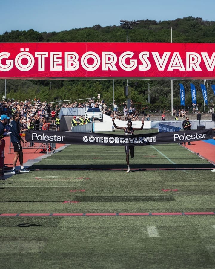 The winner of Göteborgsvarvet 2024, Moses Koech, breaking through a banner with the text 'Göteborgsvarvet' and 'Polestar'