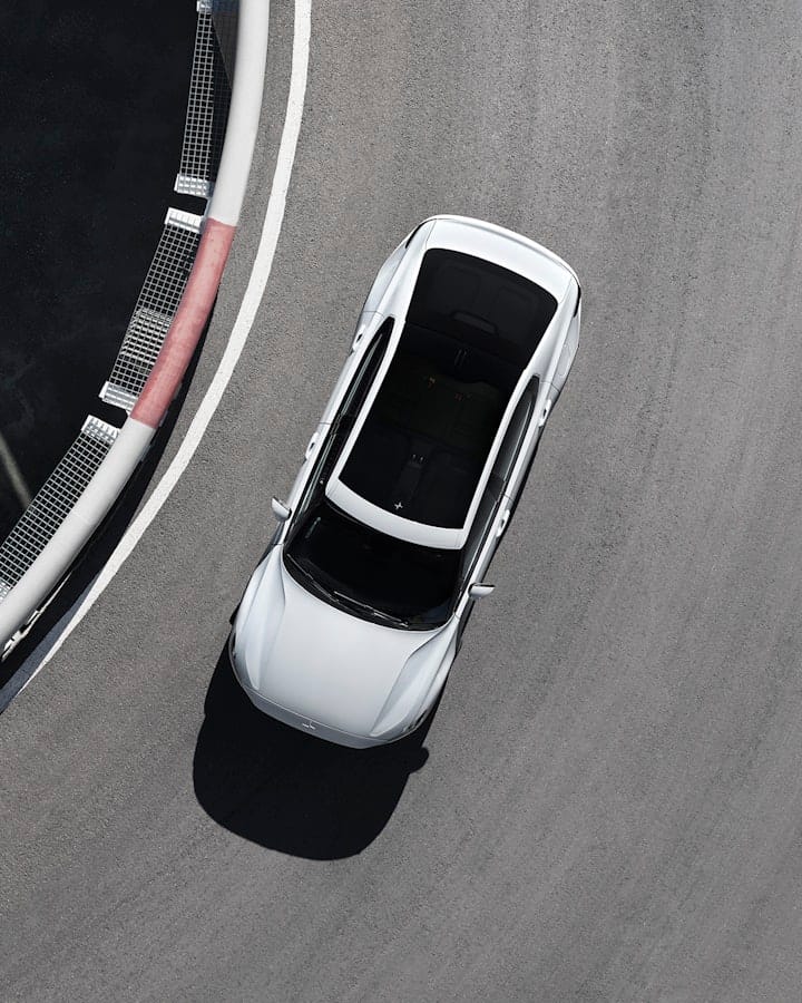 White Polestar car with panoramic roof seen from above driving on a race track
