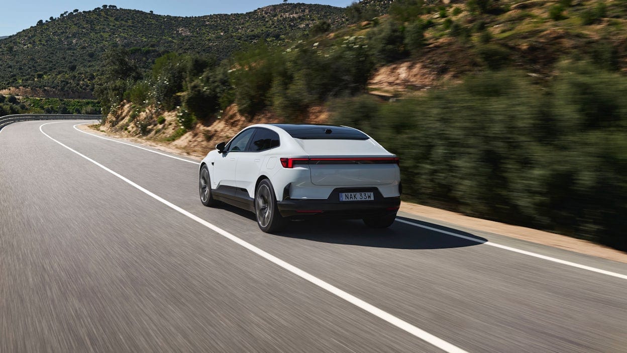 Rear view of a Polestar 4 being test-driven on an asphalt road by the press