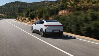 Rear view of a Polestar 4 being test-driven on an asphalt road by the press