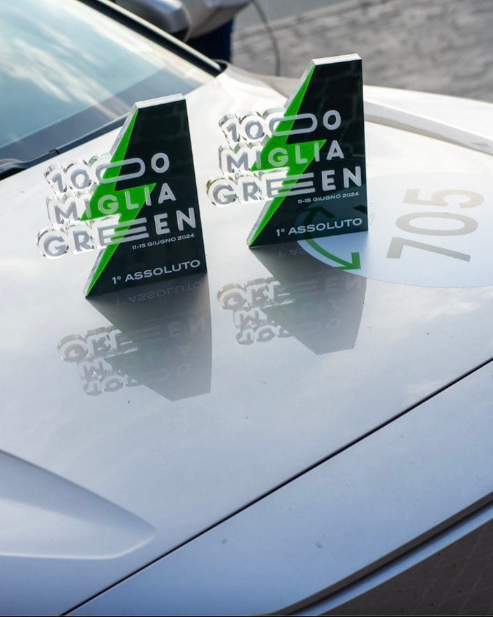 2 1000 Miglia Green trophies on the hood of a Polestar 2