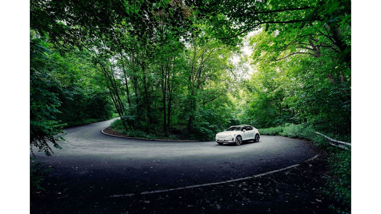 Witte elektrische Polestar 2 in een haarspeldbocht