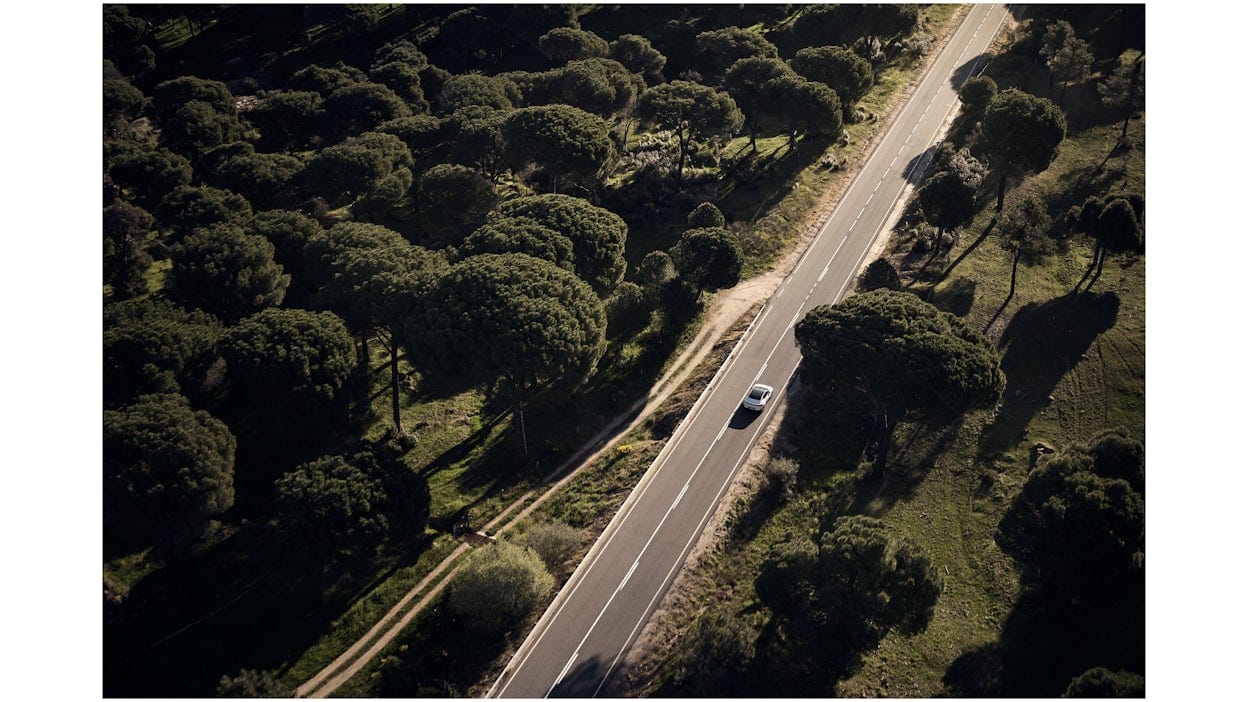 Polestar 4 driving on an empty road from an aerial view.