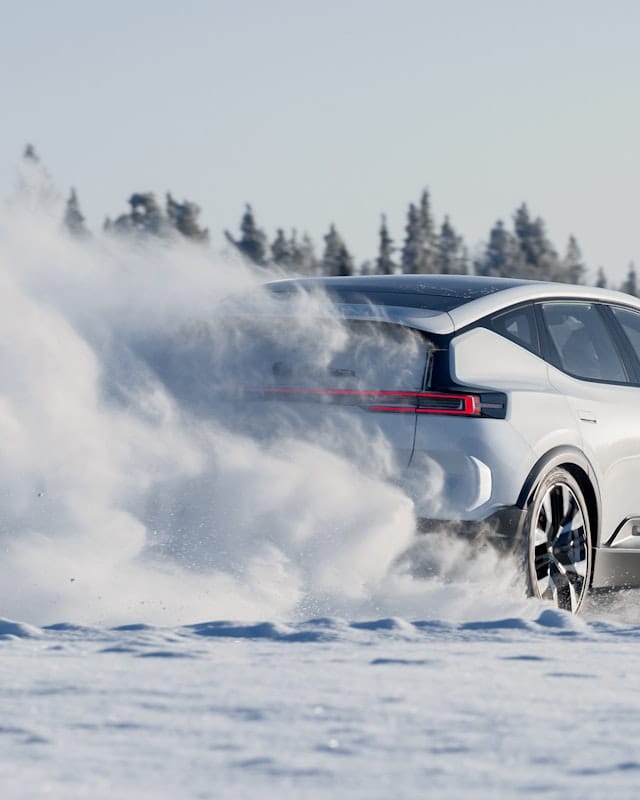 Rear end of white Polestar car driving on snow