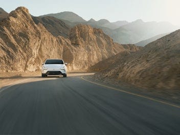 Voorkant van de Polestar 4 al rijdend door de bergachtige woestijn